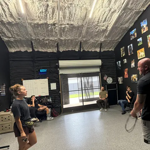 Owners watching from their seats while a trainer works a dog on leash