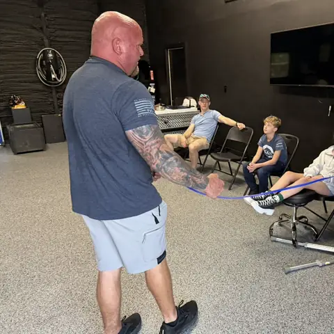 A family watching while a trainer demonstrates leash handling in the training room